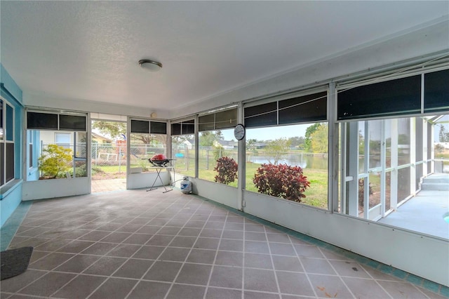 unfurnished sunroom featuring a water view