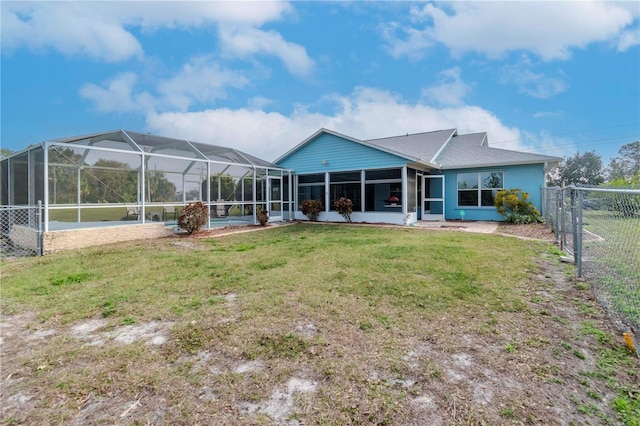 back of property with a lanai and a lawn