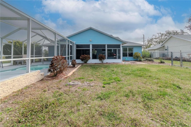 rear view of house featuring a yard, a lanai, and a fenced in pool