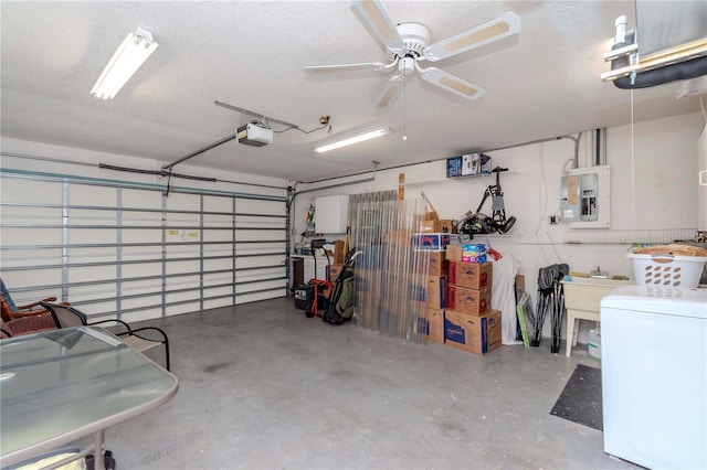 garage with ceiling fan, electric panel, a garage door opener, and washer / dryer