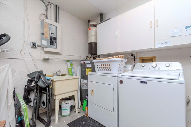 laundry room featuring water heater, cabinets, electric panel, and washer and dryer