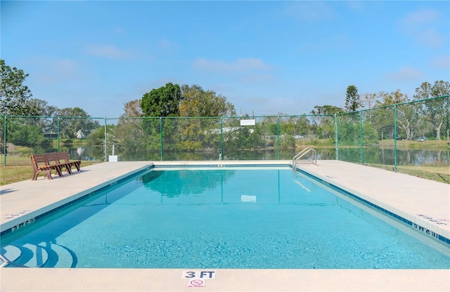 view of swimming pool with a water view and a patio area