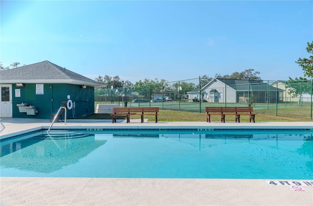 view of swimming pool with tennis court