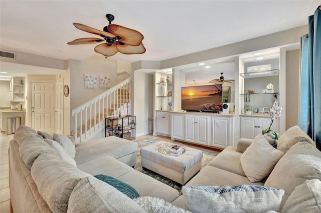 living room with light wood finished floors, stairs, visible vents, and a ceiling fan