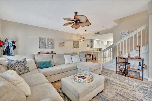 living room featuring light tile patterned floors and ceiling fan