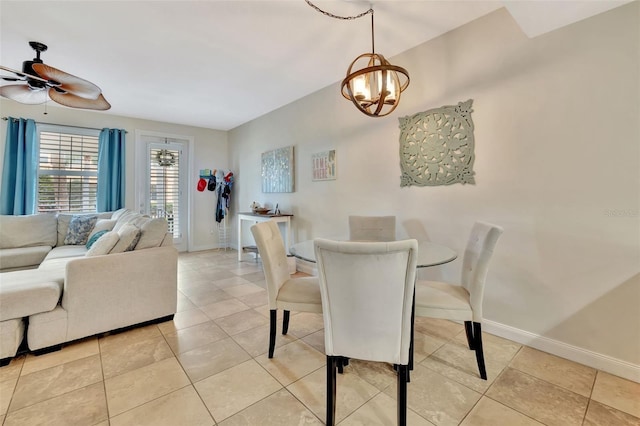 dining room with light tile patterned floors and ceiling fan with notable chandelier