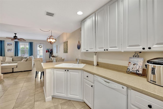 kitchen featuring pendant lighting, light countertops, open floor plan, white dishwasher, and a sink