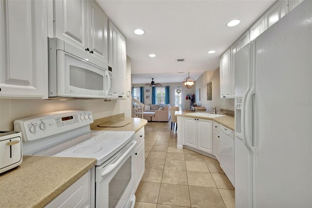 kitchen featuring white appliances, open floor plan, decorative light fixtures, light countertops, and white cabinetry