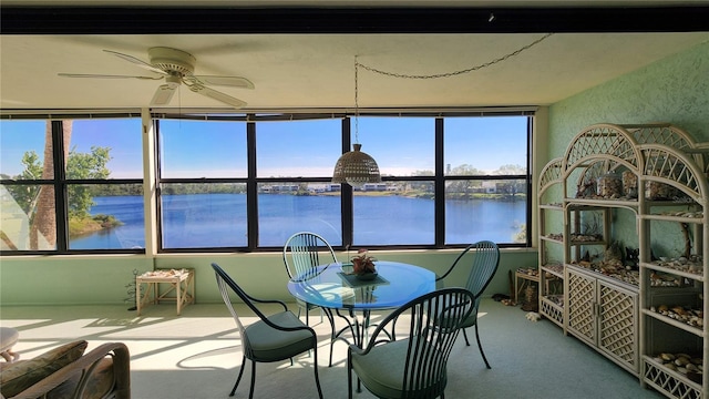 sunroom with a water view and ceiling fan