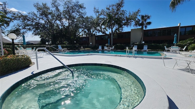 view of pool featuring a hot tub and a patio