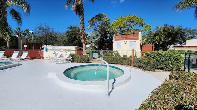 view of swimming pool featuring a hot tub and a patio area