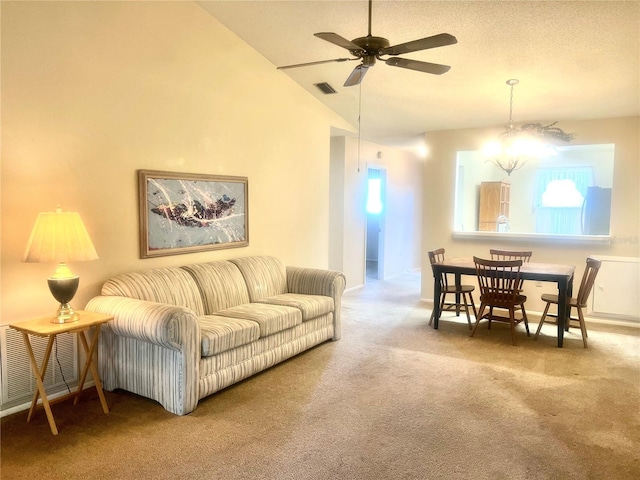 carpeted living room with vaulted ceiling and ceiling fan with notable chandelier