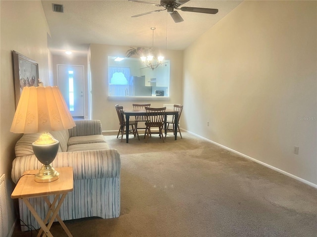 living room featuring carpet flooring and ceiling fan with notable chandelier