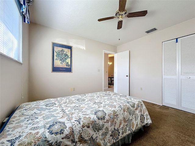 carpeted bedroom with ceiling fan and a closet