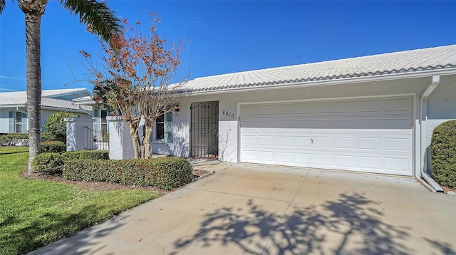 single story home featuring a garage and a front yard