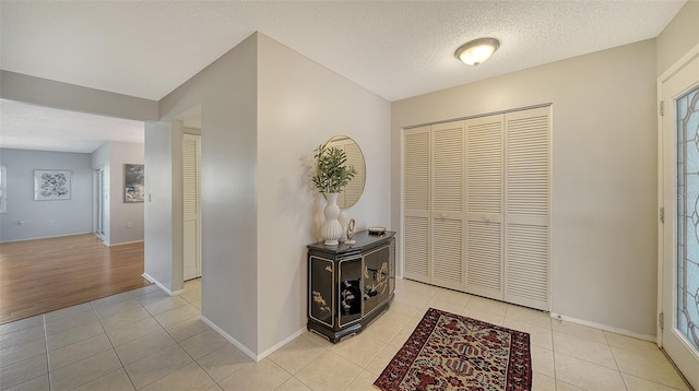 tiled entryway with a textured ceiling