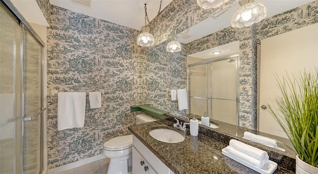 bathroom with vanity, toilet, an enclosed shower, and tile patterned flooring