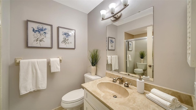 bathroom featuring vanity, toilet, and a shower with door