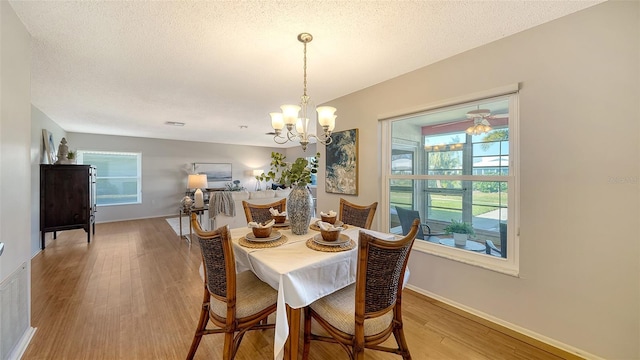 dining area with an inviting chandelier, hardwood / wood-style floors, and a textured ceiling