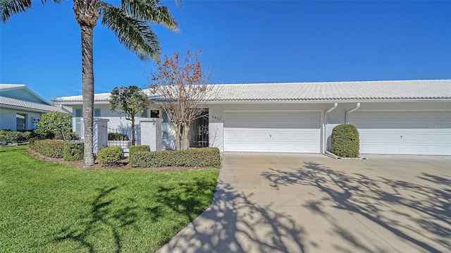 ranch-style home with a garage and a front lawn