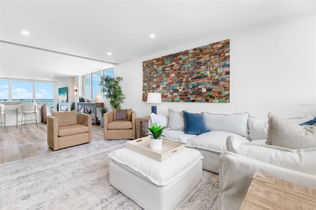 living room with a wall of windows and light wood-type flooring