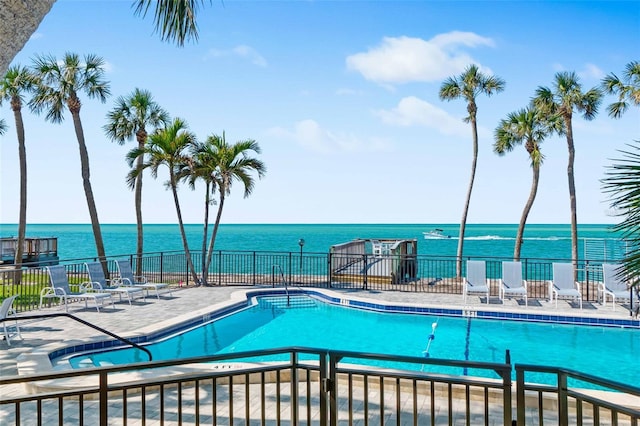 view of swimming pool with a patio and a water view