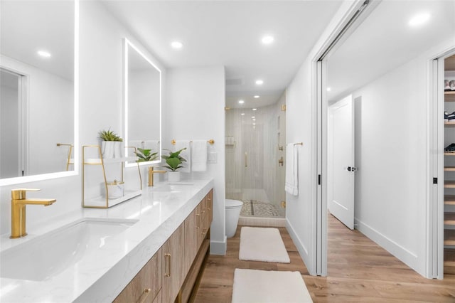 bathroom with an enclosed shower, vanity, wood-type flooring, and toilet