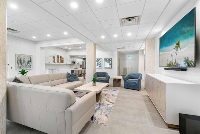 living room with light tile patterned flooring and a drop ceiling