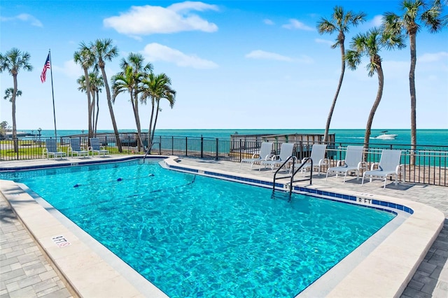 view of swimming pool featuring a water view and a patio area