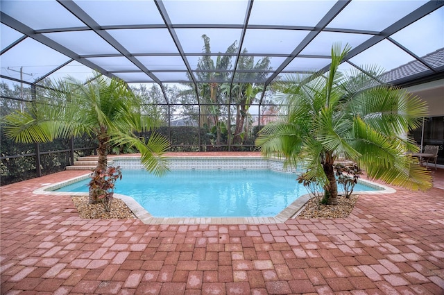 view of swimming pool with a patio area and glass enclosure