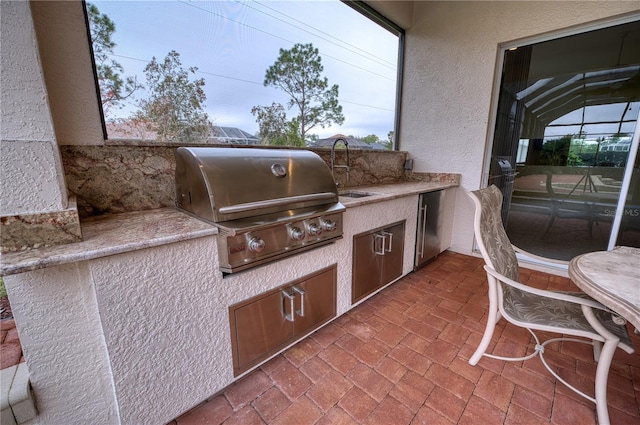 view of patio / terrace with a grill, exterior kitchen, and sink