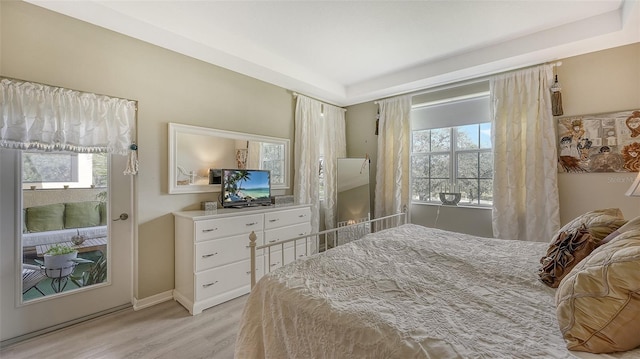 bedroom with multiple windows and light wood-type flooring