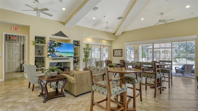 tiled dining area featuring ceiling fan, built in shelves, a wealth of natural light, and beamed ceiling