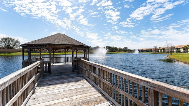 view of dock with a gazebo and a water view