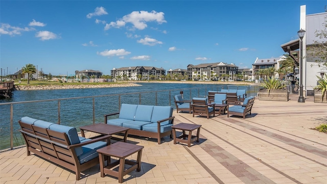 view of patio / terrace with an outdoor living space, a balcony, and a water view