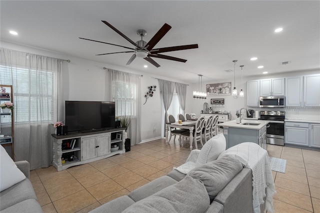 tiled living room featuring plenty of natural light, sink, and ceiling fan