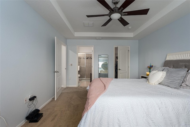 bedroom featuring ceiling fan, connected bathroom, a raised ceiling, and carpet floors