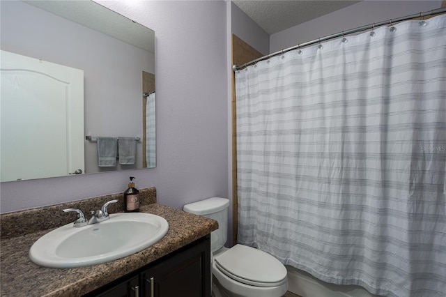 bathroom with vanity, toilet, and a textured ceiling