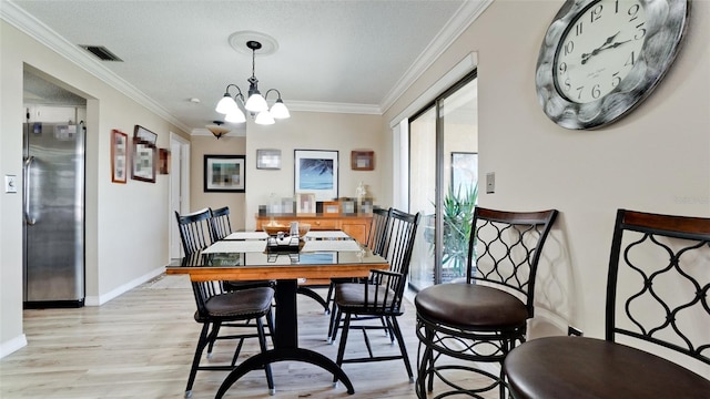 dining area featuring crown molding, a textured ceiling, a barn door, a chandelier, and light wood-type flooring