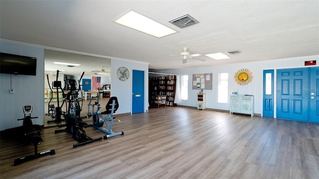 gym featuring ceiling fan, ornamental molding, and wood-type flooring