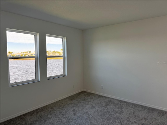 carpeted spare room featuring a water view