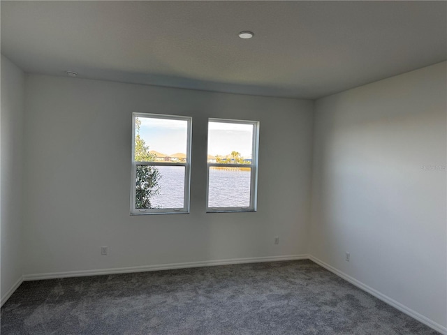 empty room with a water view and dark carpet