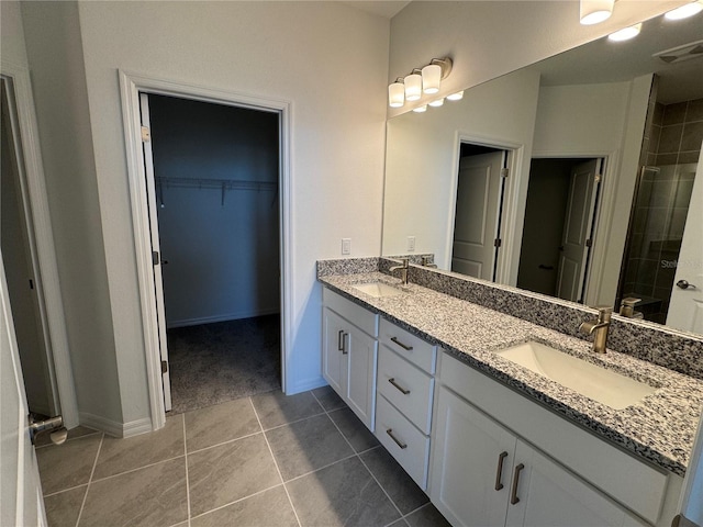 bathroom featuring vanity, tile patterned flooring, and walk in shower