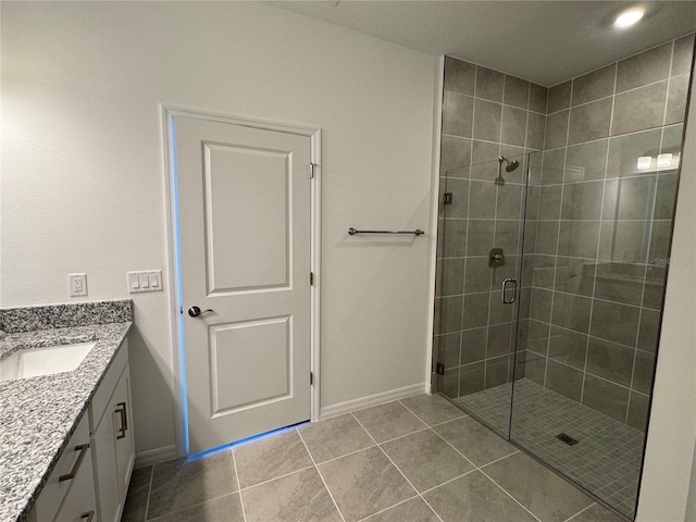 bathroom featuring vanity, tile patterned floors, and a shower with shower door