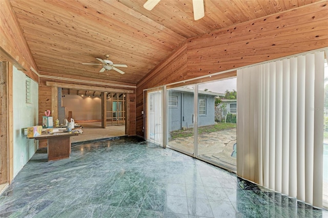 interior space with vaulted ceiling, ceiling fan, wooden ceiling, and wooden walls