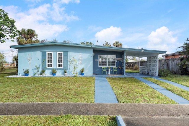 view of front of property featuring a front yard and a carport