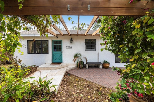 view of exterior entry with a patio area