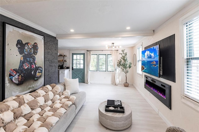 living room featuring crown molding, light hardwood / wood-style flooring, and a wealth of natural light