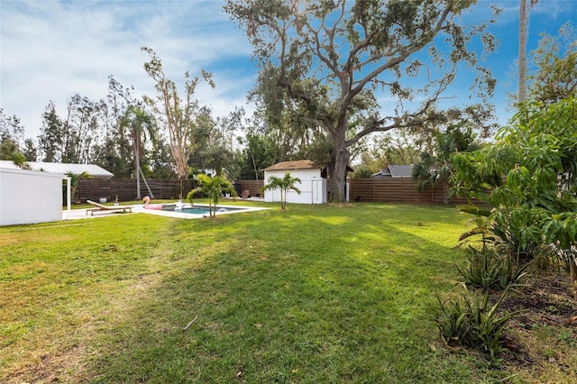 view of yard with a storage unit and a fenced in pool