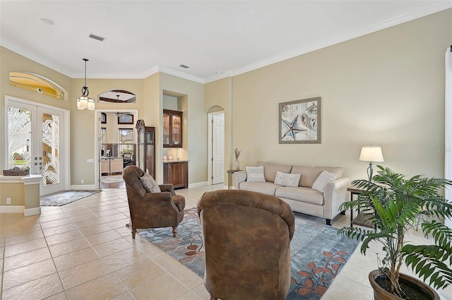 tiled living room featuring crown molding and french doors